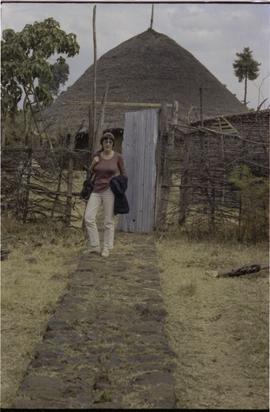 Lorna R. Marsden and a straw or mud  hut