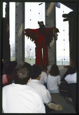 Children watch a performer in a bird costume