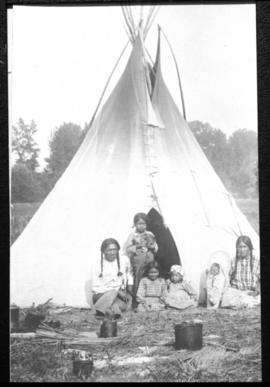 Portrait of man, woman, and children in front of tipi