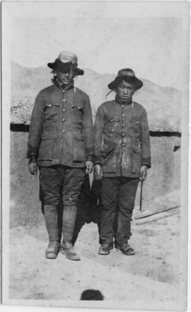 Two men standing near wall