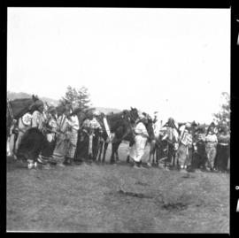 Group shot of individuals standing outside with horses