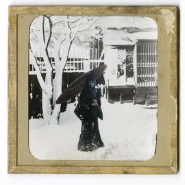 Woman holding parasol outside in snow