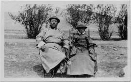 Man and child seated outside and posed for photograph