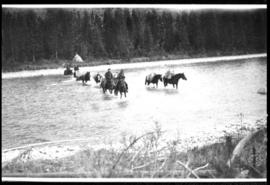 Men on horseback crossing a river