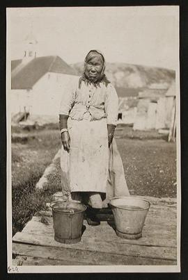 Woman Standing with Two Buckets at her Feet