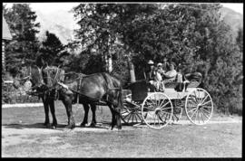 Portrait of man, woman, and two children in a horse-drawn wagon