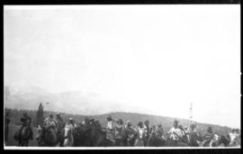 Group photo of people on horseback with mountains in distance