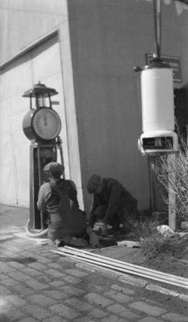 Two men installing a gasoline pump