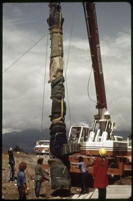 Charlie James totem pole being liften by a crane