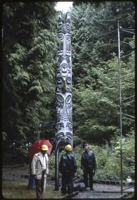 Workers prepare to move a totem pole