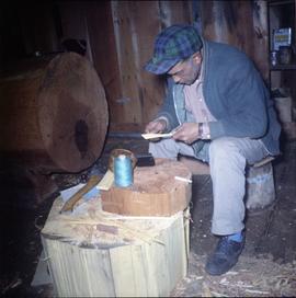 Man carving in shed, Alert Bay (?)