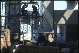 Workers prepare to raise a totem pole in the Museum of Anthropology