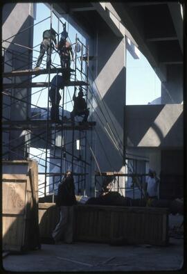 Workers prepare to raise a totem pole in the Museum of Anthropology