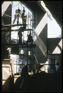 Men preparing to hoist a totem pole into position
