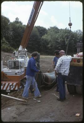 A totem pole being lowered onto the ground