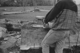 [Ron uses chainsaw to continue shaping log]