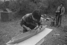 [Norman making final adjustments to model canoe before first steam]