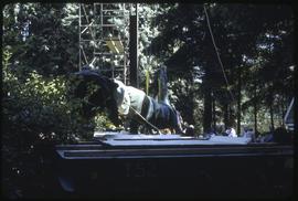 A totem pole being lowered onto a trailer