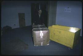 Man moving a box of items to the new Museum of Anthropology