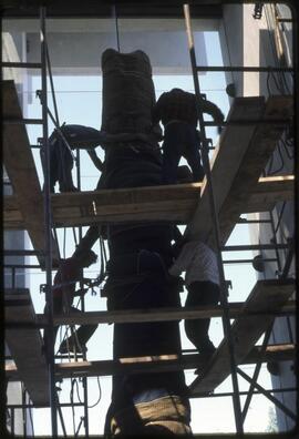 Workers securing a totem pole in the Museum of Anthropology
