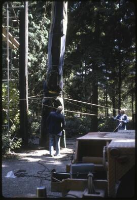 A totem pole being lowered from its position in Totem Park
